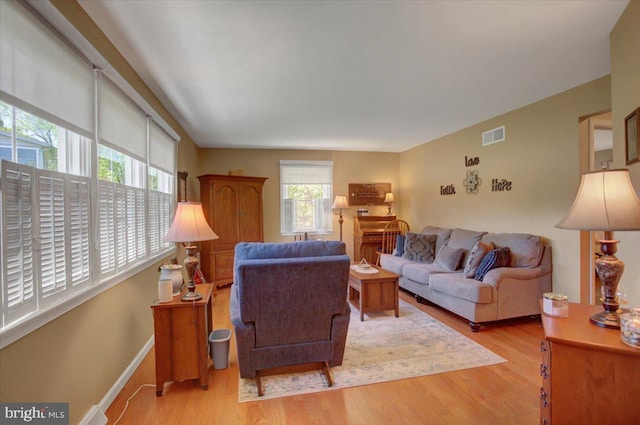 living area featuring visible vents and wood finished floors