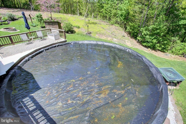 view of pool with a fire pit and a yard