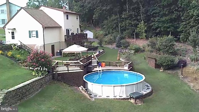 outdoor pool with a yard, a gazebo, and a wooden deck