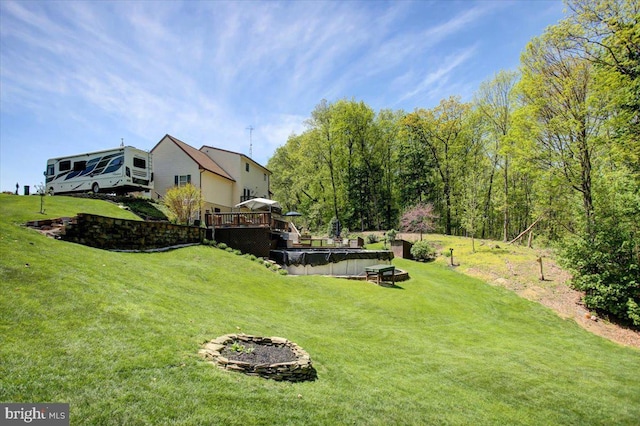 view of yard featuring a covered pool and a deck