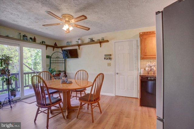 dining area with a textured ceiling, ceiling fan, and light wood-style floors