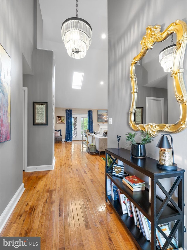 13295 Rollie Road E Rd, Bishopville, MD 21813 - hall featuring a chandelier, high vaulted ceiling, hardwood / wood-style flooring, and baseboards