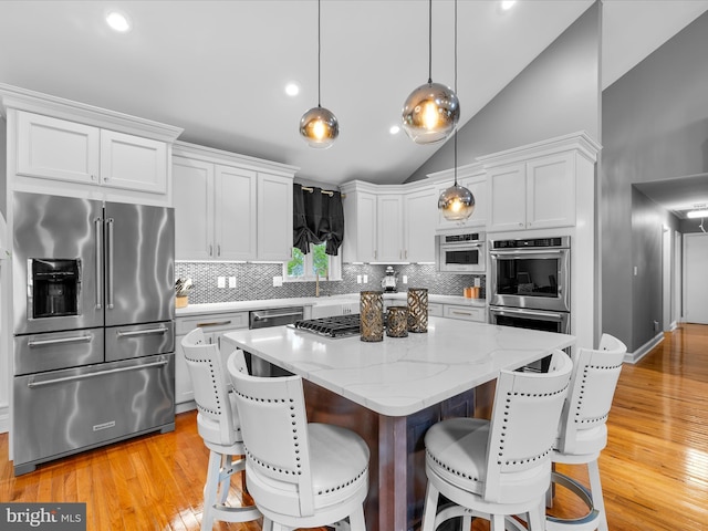 13295 Rollie Road E Rd, Bishopville, MD 21813 - kitchen with appliances with stainless steel finishes, decorative backsplash, vaulted ceiling, light wood-type flooring, and white cabinets
