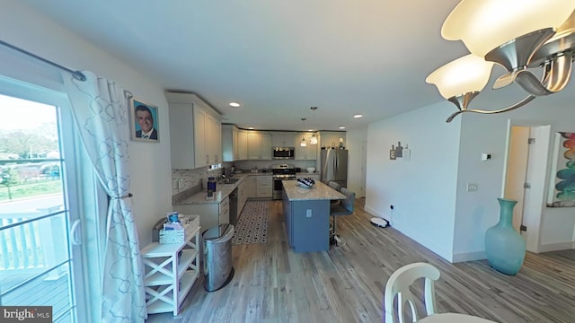 13 Verbena Dr, Lancaster, PA 17602 - kitchen with a breakfast bar area, a center island, stainless steel appliances, light wood-type flooring, and pendant lighting