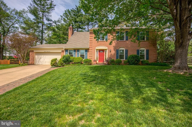 colonial-style house with a chimney, a garage, brick siding, fence, and a front lawn