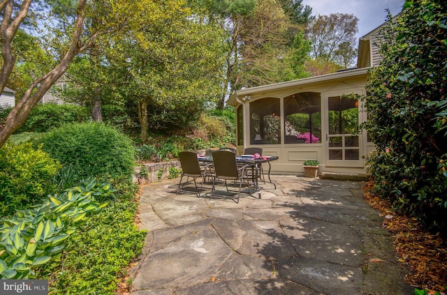view of patio / terrace featuring outdoor dining area and a sunroom