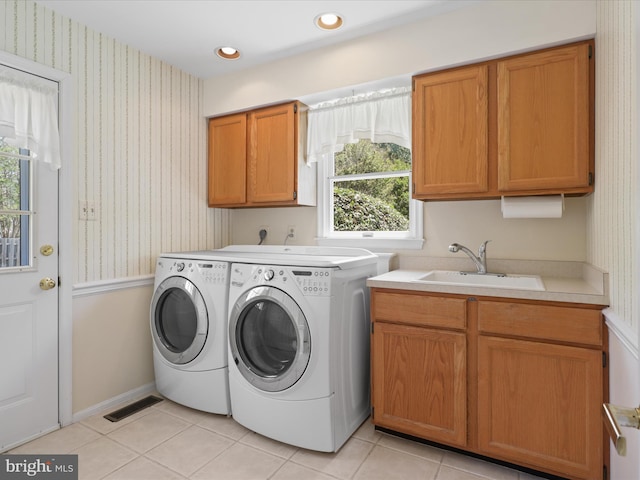laundry room featuring cabinet space, a sink, wallpapered walls, visible vents, and washing machine and dryer