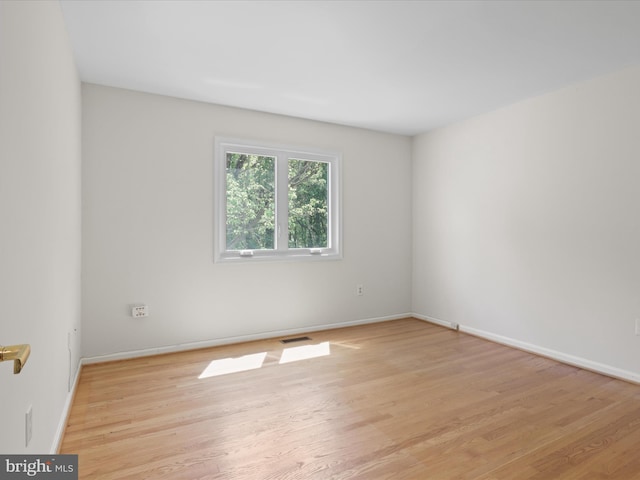 empty room featuring baseboards, visible vents, and light wood-style flooring