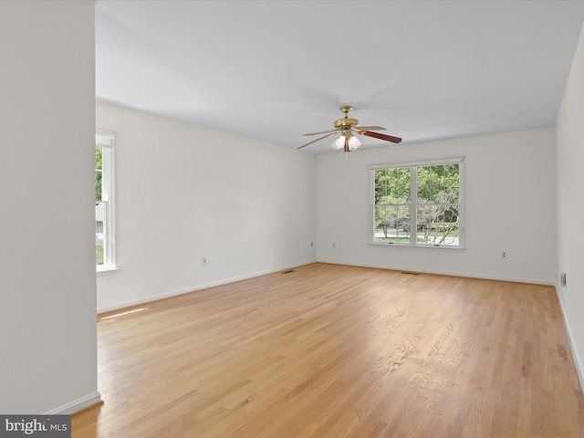 unfurnished room with baseboards, ceiling fan, light wood-style flooring, and visible vents