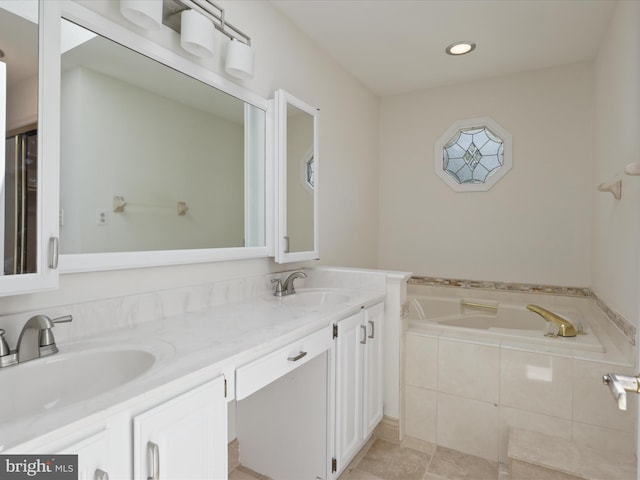 full bathroom with double vanity, recessed lighting, a sink, and a garden tub