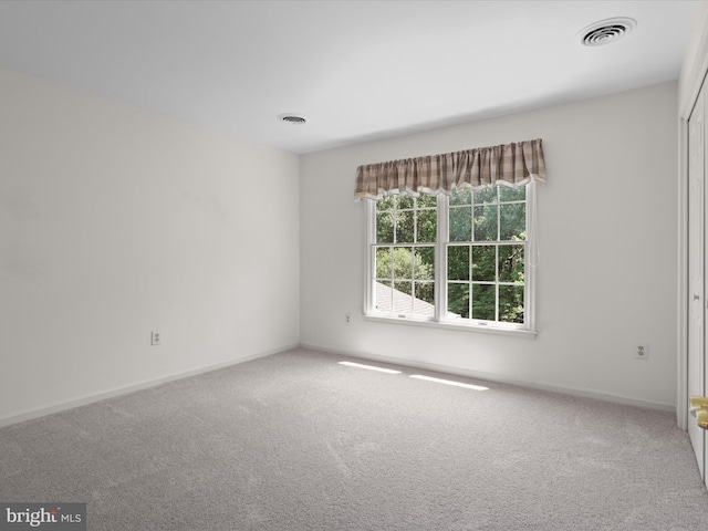 unfurnished room featuring visible vents, carpet flooring, and baseboards