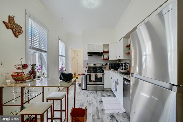 524 S Luzerne Ave, Baltimore, MD 21224 - kitchen featuring appliances with stainless steel finishes, open shelves, under cabinet range hood, white cabinets, and light wood-style floors