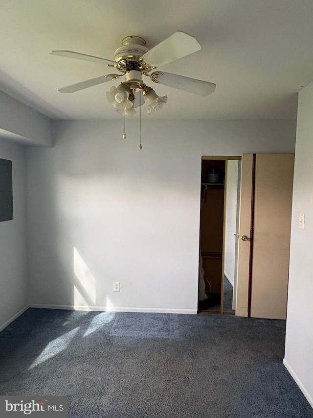 carpeted spare room featuring baseboards and a ceiling fan