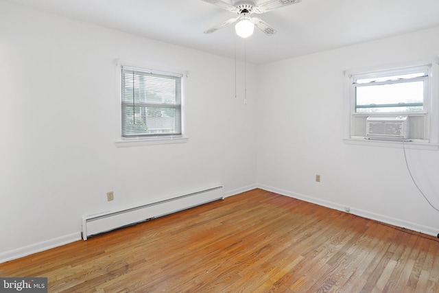 empty room with a baseboard radiator, healthy amount of natural light, light wood-style flooring, and baseboards