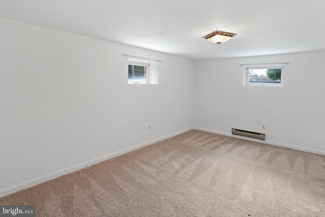 below grade area featuring a baseboard radiator, healthy amount of natural light, carpet, and baseboards
