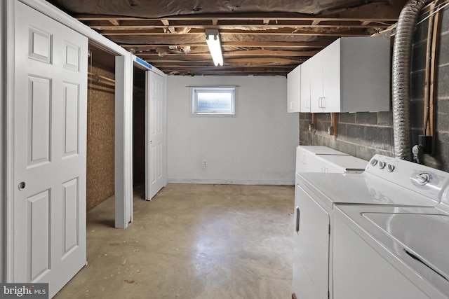 clothes washing area with washer and dryer and cabinet space