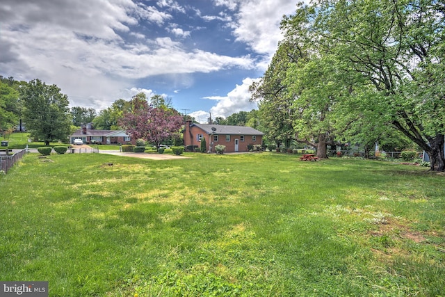 view of green lawn with view of wooded area