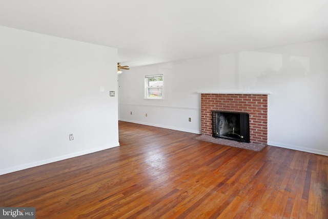 unfurnished living room featuring wood finished floors, a fireplace, and baseboards