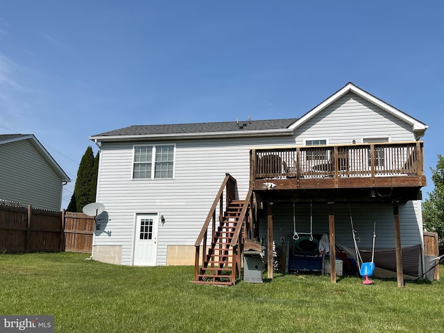 back of property featuring fence, a deck, roof with shingles, a yard, and stairway