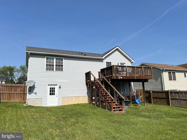 rear view of house with a fenced backyard, a wooden deck, a yard, and stairway