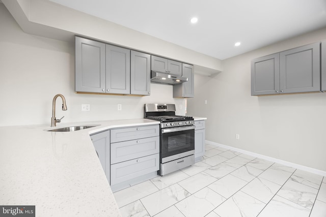 6 Plymouth Ter, Egg Harbor Township, NJ 08234 - kitchen with marble finish floor, stainless steel gas stove, under cabinet range hood, a sink, and gray cabinetry