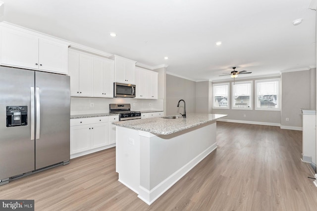 kitchen featuring crown molding, ceiling fan, a sink, light wood-style floors, and stainless steel appliances