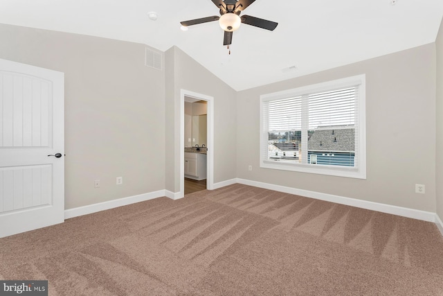 unfurnished bedroom with carpet floors, baseboards, visible vents, and lofted ceiling
