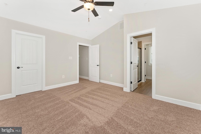 unfurnished bedroom featuring visible vents, lofted ceiling, baseboards, ceiling fan, and carpet