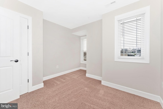 spare room featuring visible vents, carpet flooring, and baseboards