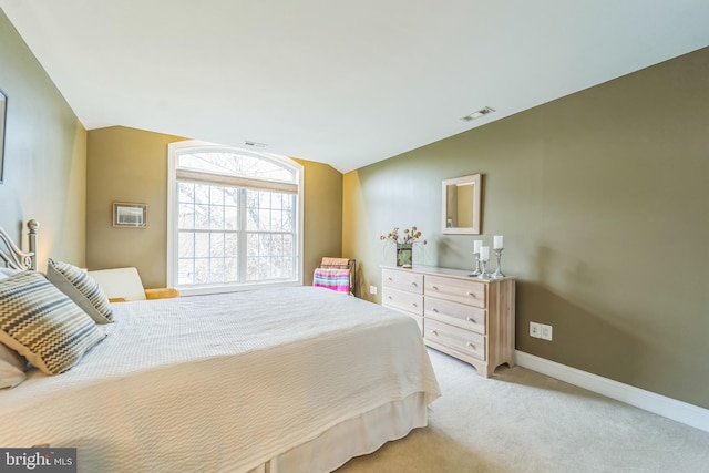 bedroom with vaulted ceiling, visible vents, baseboards, and light carpet
