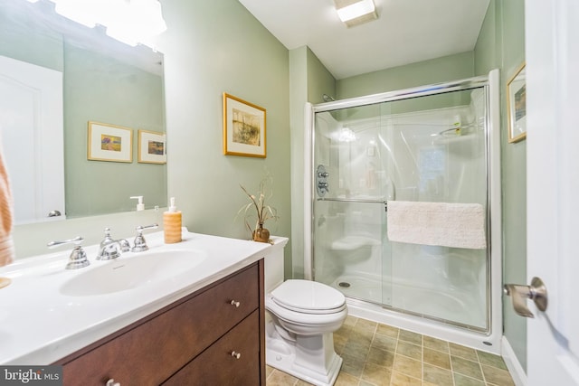 full bathroom featuring a stall shower, vanity, and toilet