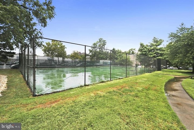 view of sport court featuring a yard and fence