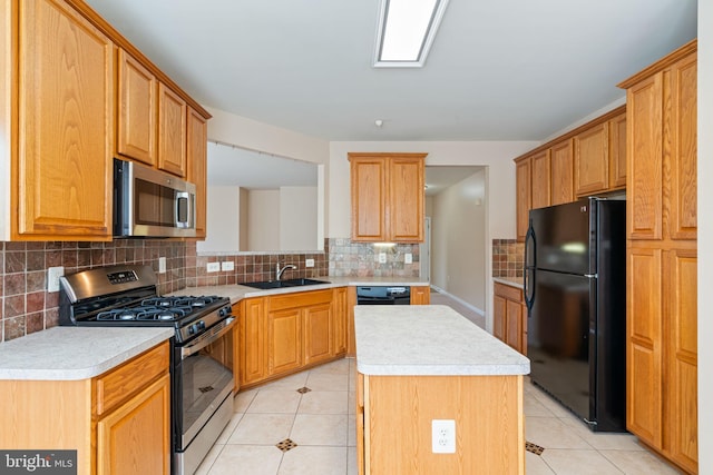 kitchen with decorative backsplash, light countertops, a sink, light tile patterned floors, and black appliances