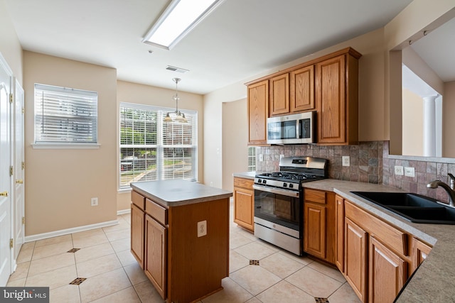 kitchen with visible vents, light tile patterned flooring, a sink, appliances with stainless steel finishes, and backsplash