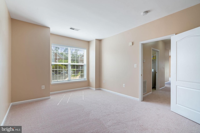 unfurnished room with visible vents, baseboards, and light carpet