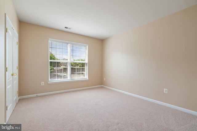 carpeted empty room with baseboards and visible vents