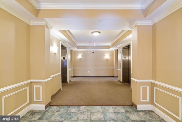 hall featuring carpet floors, ornamental molding, a tray ceiling, and elevator