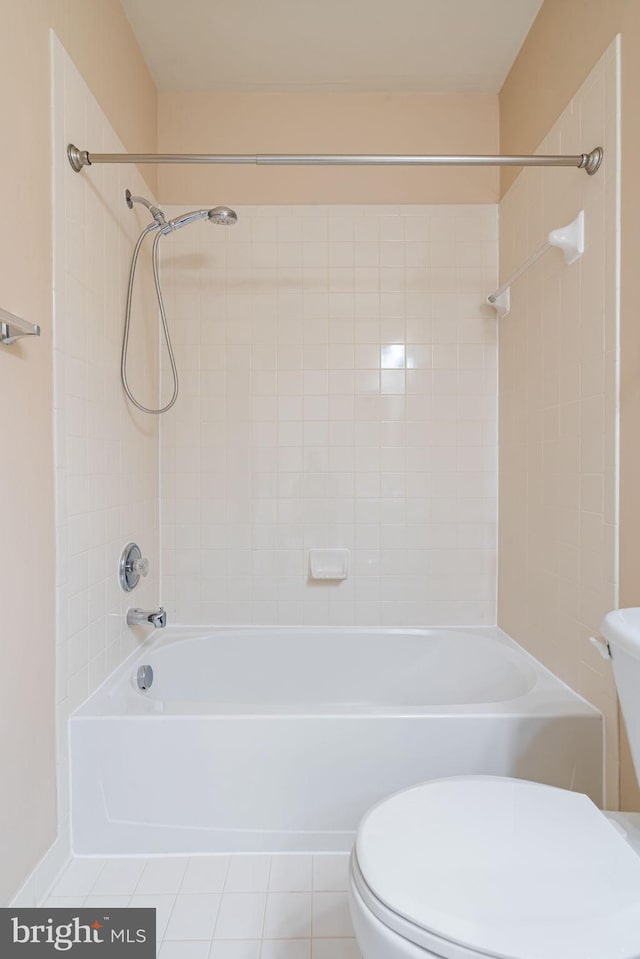 bathroom featuring washtub / shower combination, tile patterned floors, and toilet