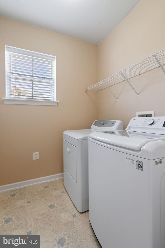 washroom featuring baseboards, laundry area, and washer and dryer