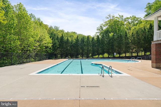 pool featuring fence and a patio area