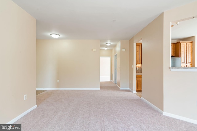 empty room with light colored carpet and baseboards