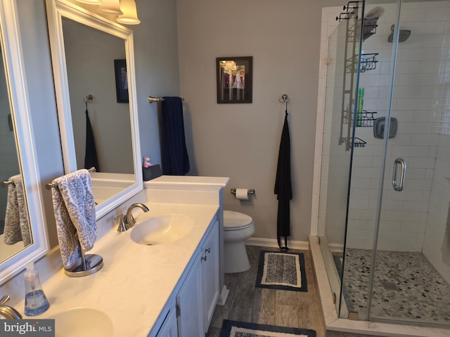 full bath with double vanity, a sink, toilet, and a shower stall