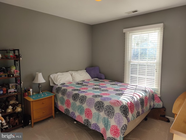 carpeted bedroom featuring visible vents