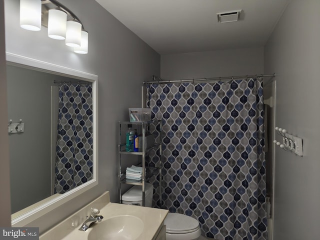 full bathroom with vanity, a shower with curtain, toilet, and visible vents