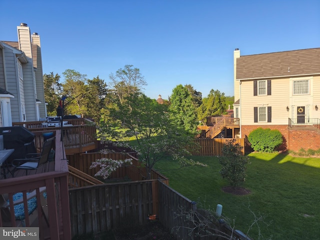 view of yard featuring fence private yard, stairway, and a deck