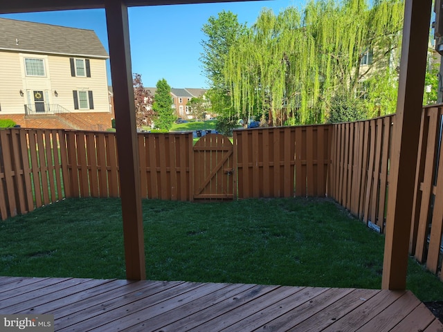 view of yard with a fenced backyard, a gate, a wooden deck, and a residential view
