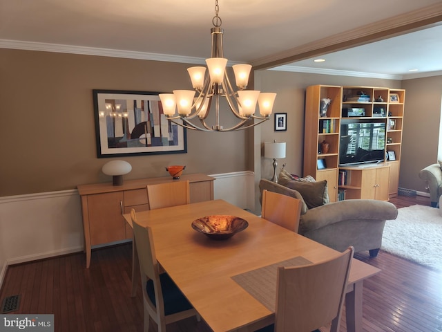 dining space featuring crown molding, a chandelier, hardwood / wood-style flooring, and visible vents