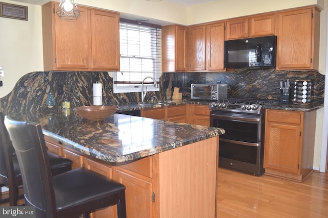 1716 Pebble Beach Dr, Bowie, MD 20721 - kitchen with a peninsula, black microwave, range with two ovens, a sink, and backsplash