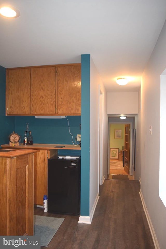 1716 Pebble Beach Dr, Bowie, MD 20721 - kitchen with brown cabinets, baseboards, refrigerator, and dark wood-style floors