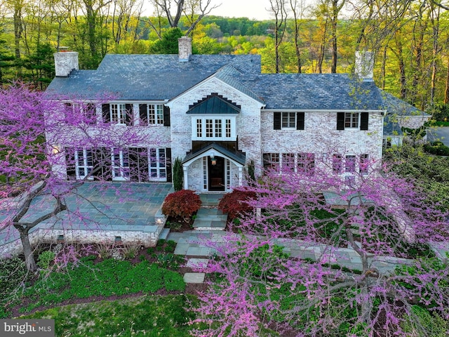 view of front of house featuring a high end roof and a chimney